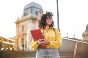 Studentessa sorridente con documenti in mano durante un'esperienza Erasmus all'estero